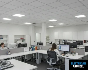 Image of an office space with ceiling lights and workstations.